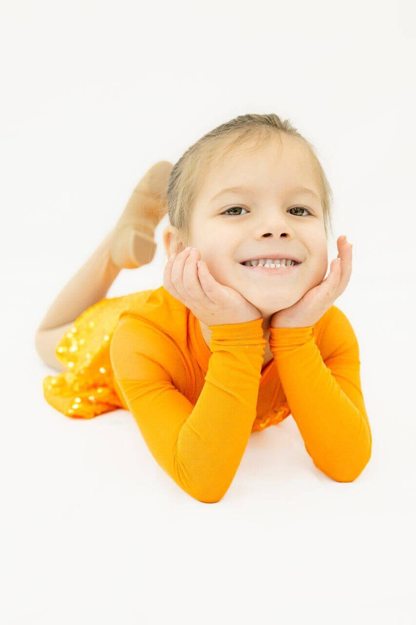Smiling young Tempo dancer in an orange sequin costume